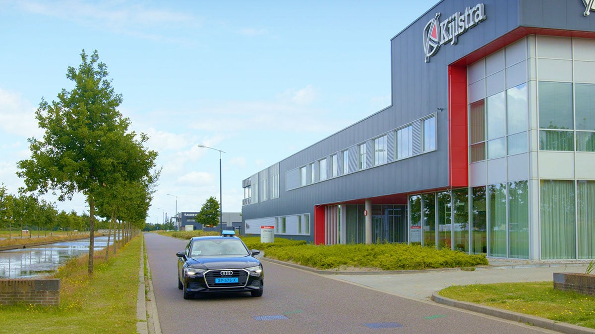 Taxi rijdt langs het gebouw van Kijlstra