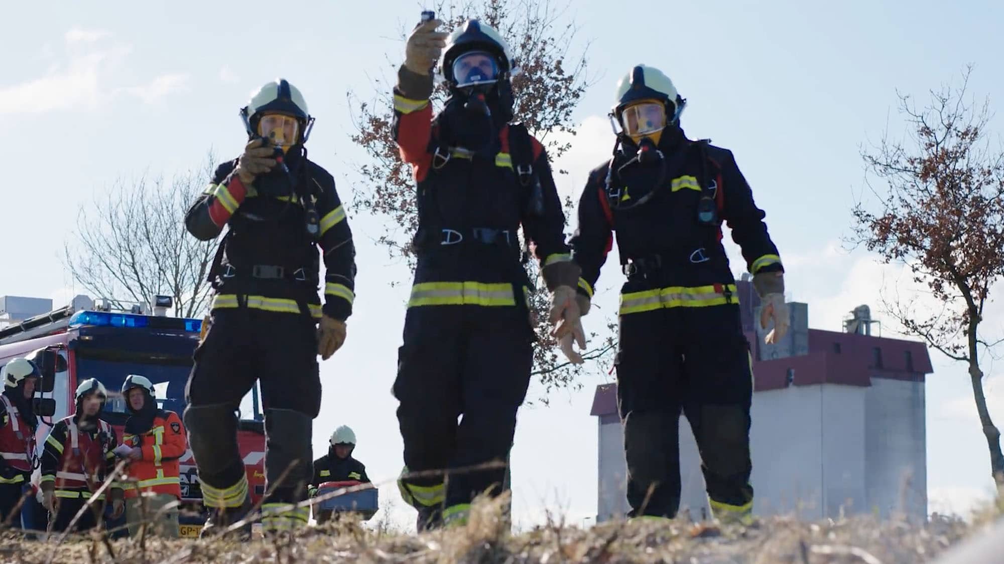 Drie brandweermannen onderzoeken een met gif verpest gebied